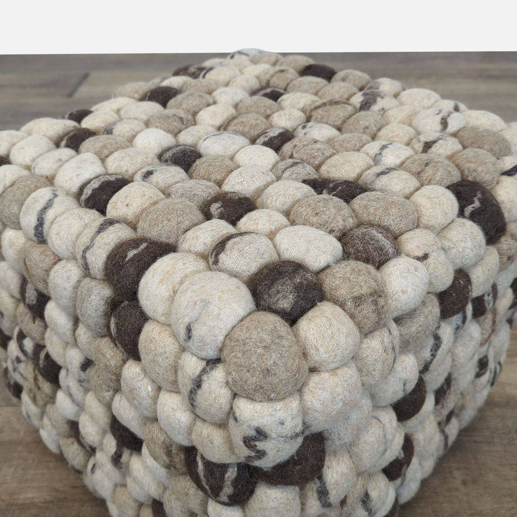 Close-up of soft, textured taupe, charcoal, and gray wool ottoman from Reperch, showing checkerboard pattern.