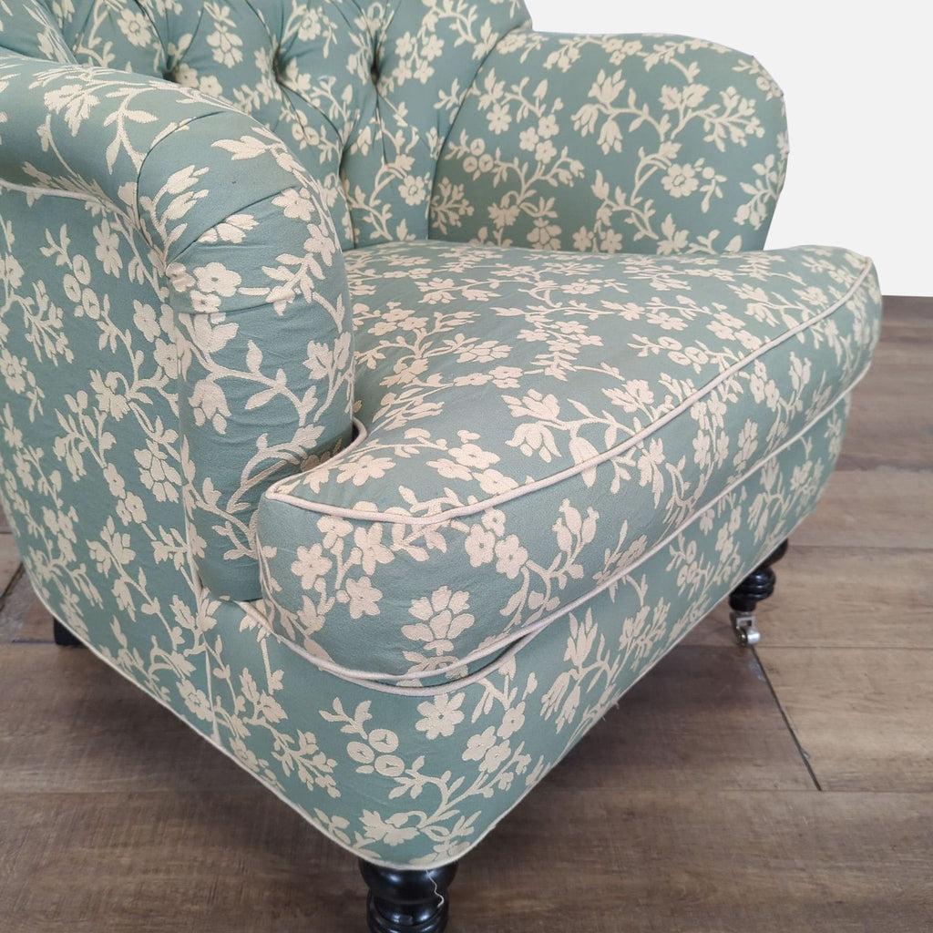 3. Close-up of Cisco Brothers lounge chair with detailed floral upholstery, tufting, and wood leg with caster.