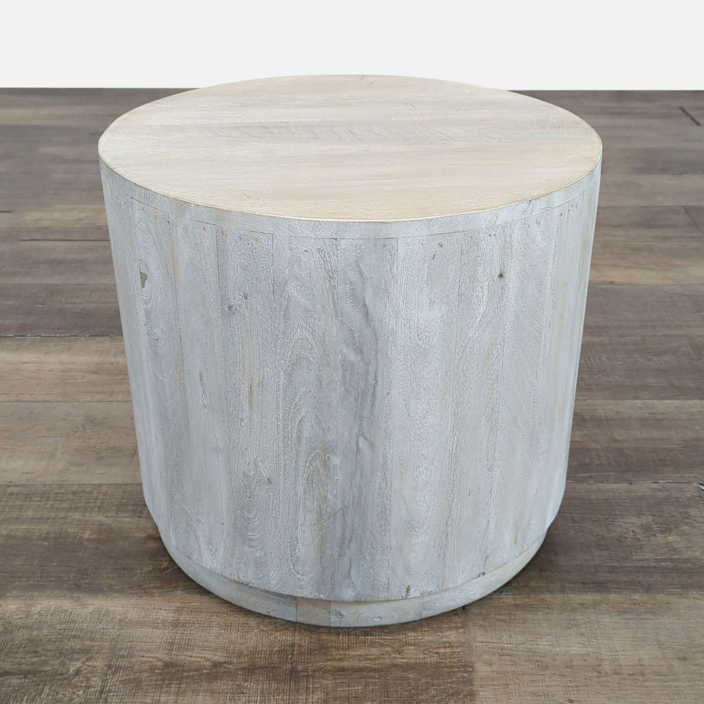 1. Round wooden side table from Reperch with a light finish, placed on a wooden floor.  