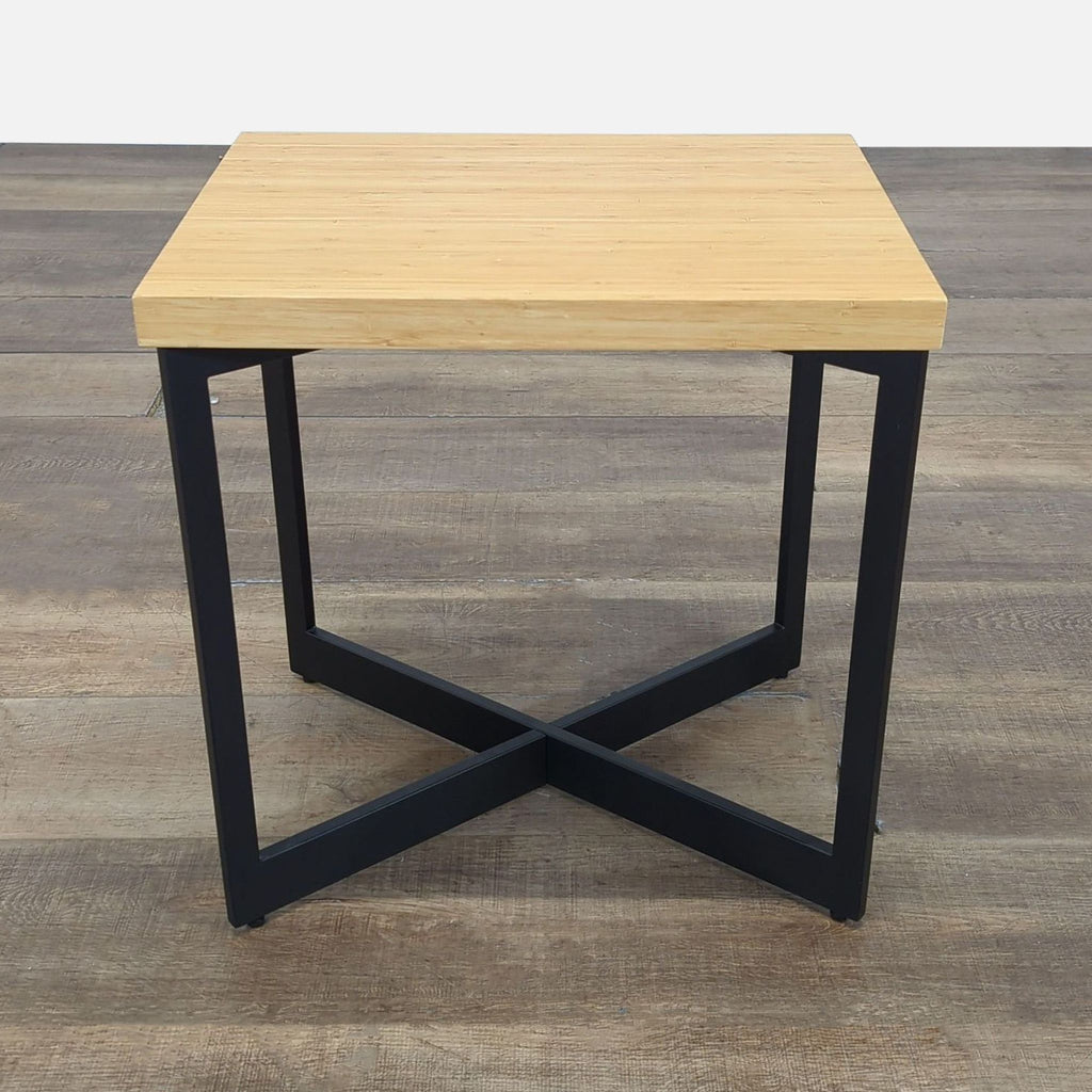 Modern side table by Reperch with a light wood top and black metal X-base, side and front angle views.  