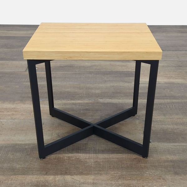 Modern side table by Reperch with a light wood top and black metal X-base, side and front angle views.  