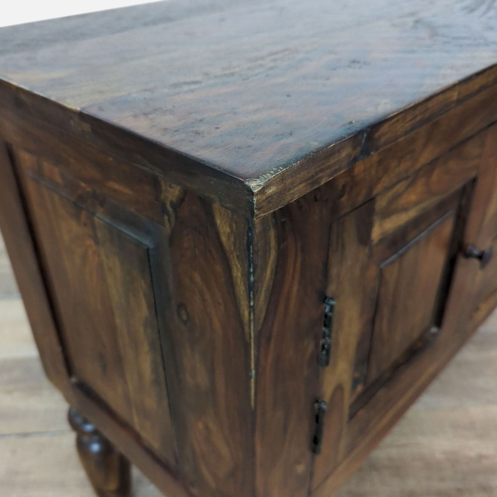 3. Close-up of the sideboard’s corner, highlighting the wood grain and molding detail of the cabinet door.