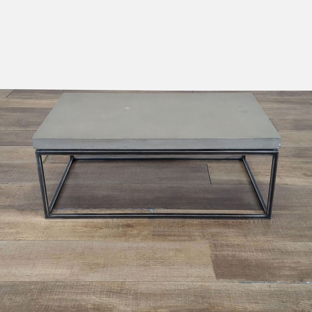 1. Structube coffee table with a concrete top and black metal frame on wooden flooring, front view.  