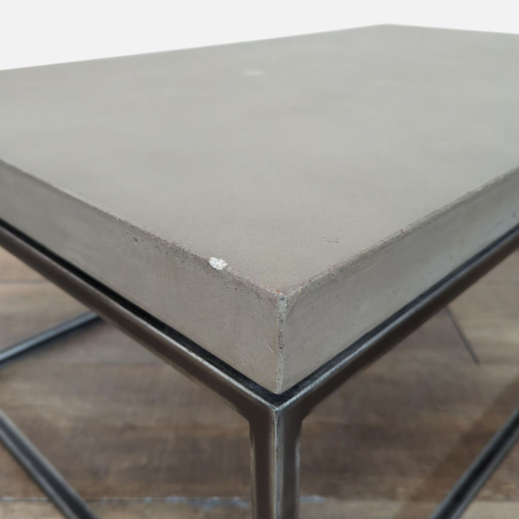 2. Close-up of the Structube coffee table’s corner, showing the concrete top and metal frame structure.  
