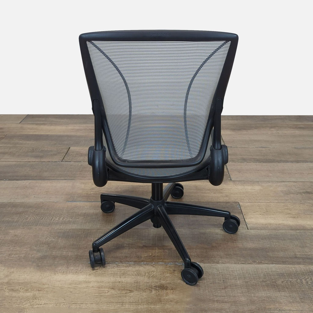 Rear view of a mesh-back Humanscale chair highlighting the adaptive tri-panel “Form-Sensing Mesh” structure.