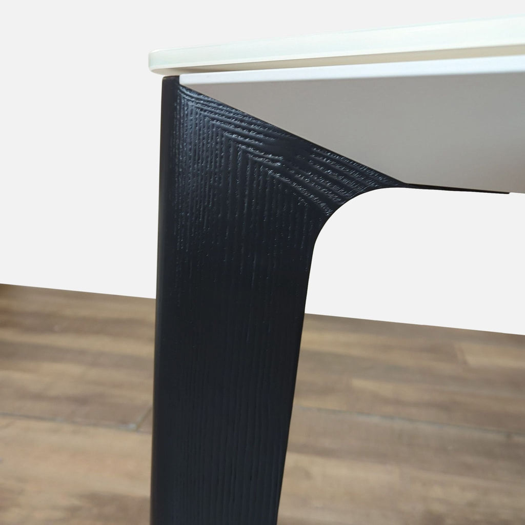 3. Detail view of Bontempi Versus table leg, highlighting textured lacquered wood and seamless glass top finish.