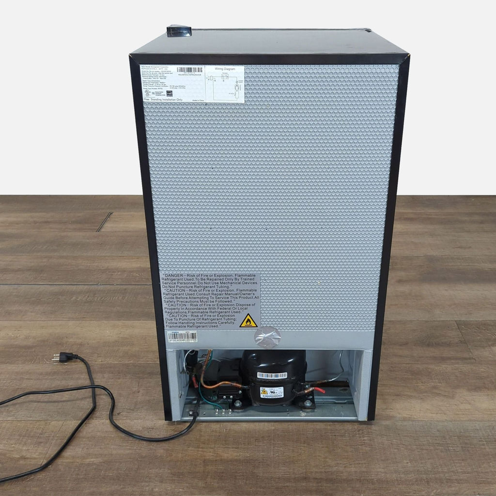 2. Rear view of the Kenmore mini fridge, displaying compressor, wiring, and safety labels on the back panel.