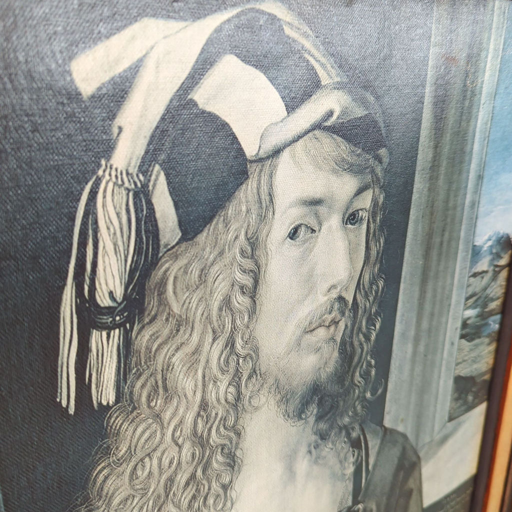 Close-up of Albrecht Dürer’s self-portrait print, highlighting his detailed face, curly hair, and ornate hat.