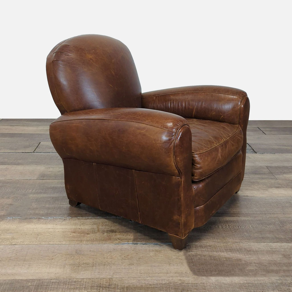 2. Angled side view of a Mitchell Gold leather lounge chair, showcasing its curved design and plush, deep seat.