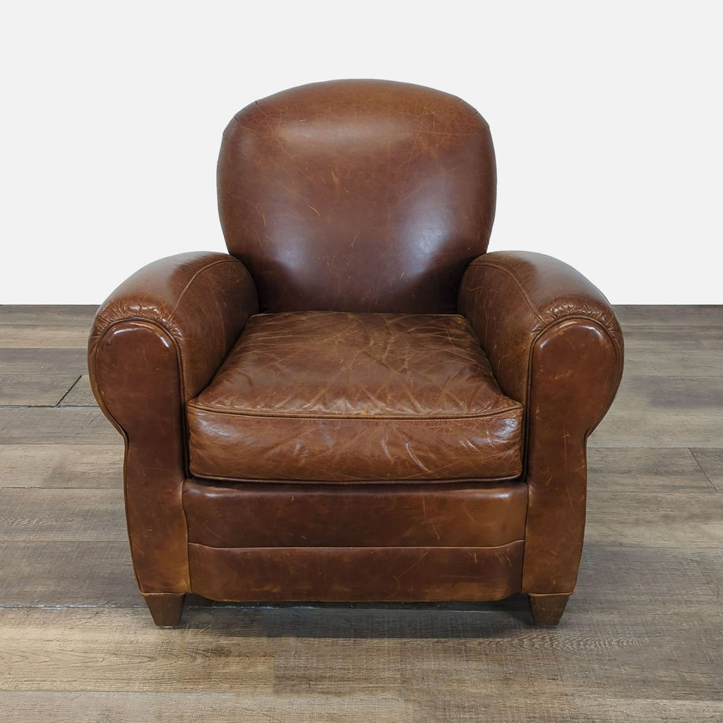 1. Front view of a Mitchell Gold lounge chair featuring a rounded back, deep seat, and brown leather upholstery.