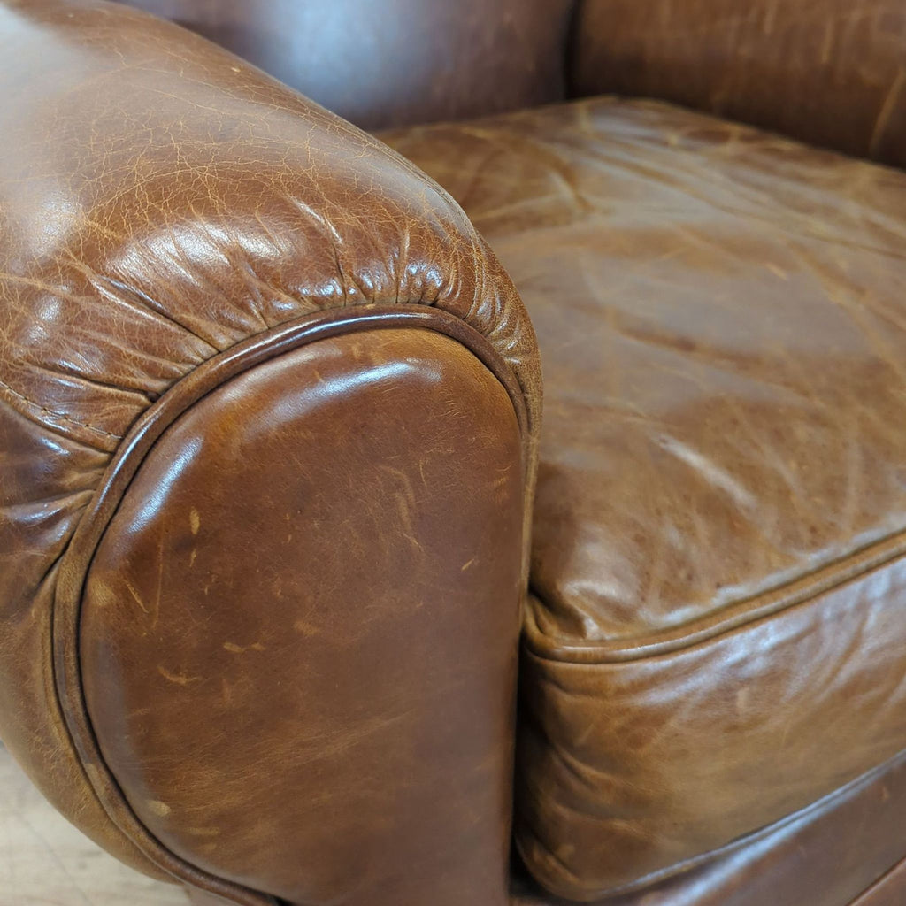 3. Close-up of the Mitchell Gold lounge chair detailing the brown leather upholstery and rounded armrest.