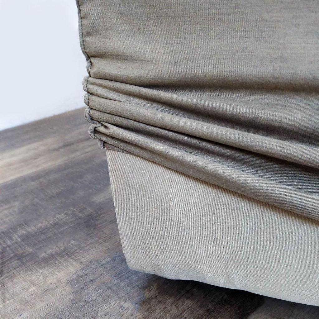 2. Close-up of the beige slipcover fabric detail on the Reperch Bridge lounge ottoman.