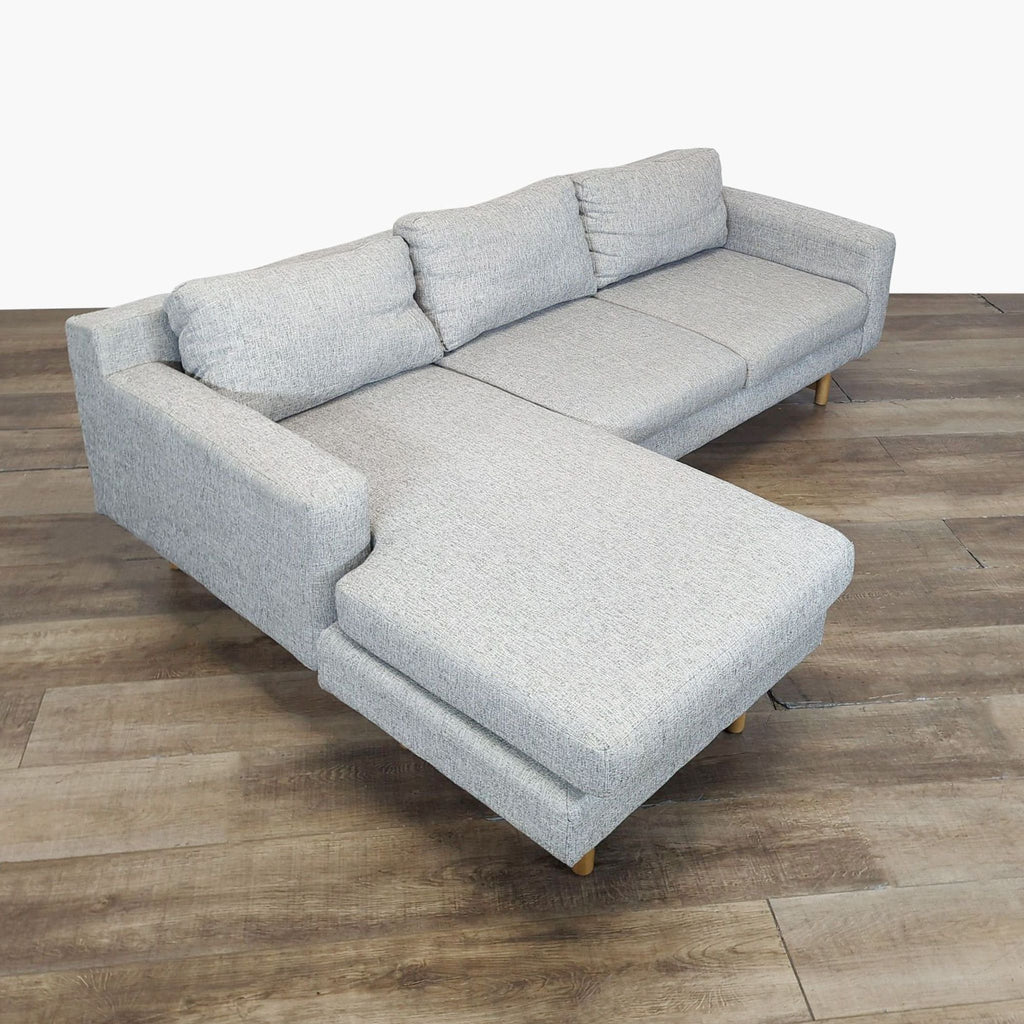 2. Angled view of a modern Reperch sectional, featuring light gray fabric, plush cushions, and sturdy wood legs.