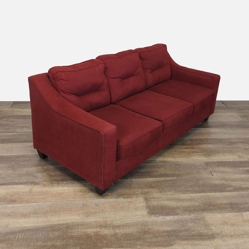 Angled side view of a Reperch 3-seat red sofa showing tufted back cushions and track arms.
