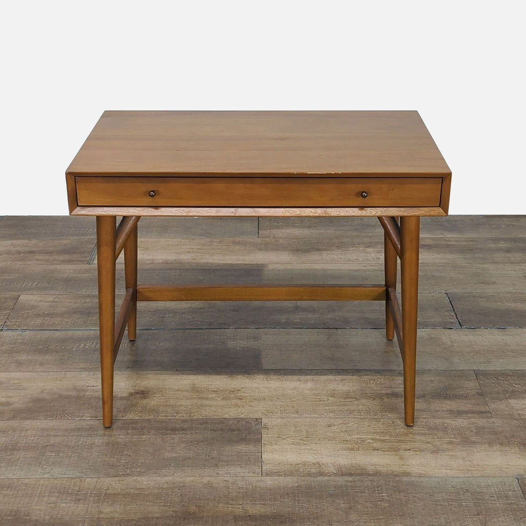 Mid-century modern wooden desk from West Elm with a single front drawer, shown on a wooden floor.  