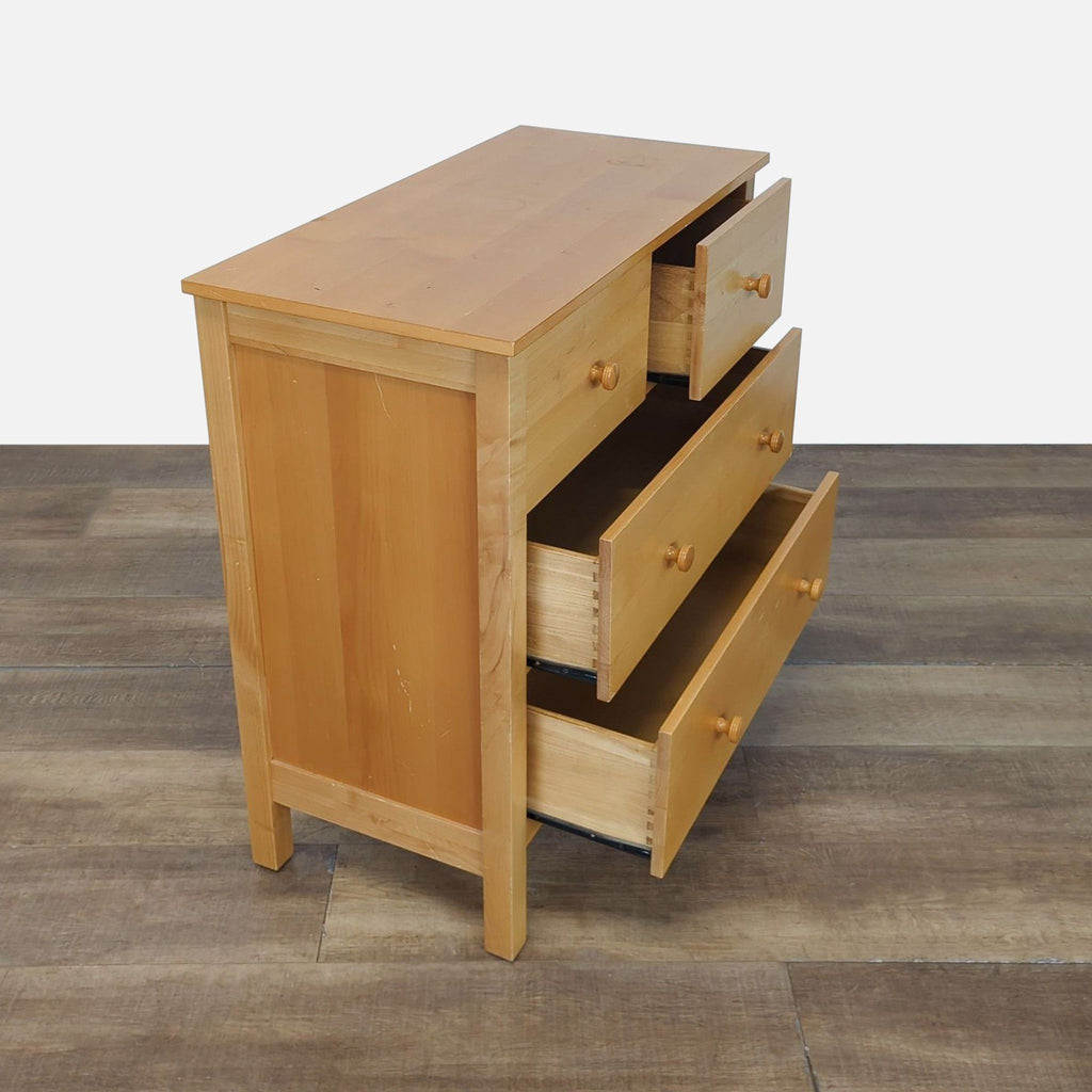 2. Side view of a solid wood dresser with three open drawers, highlighting simple dovetail joinery.