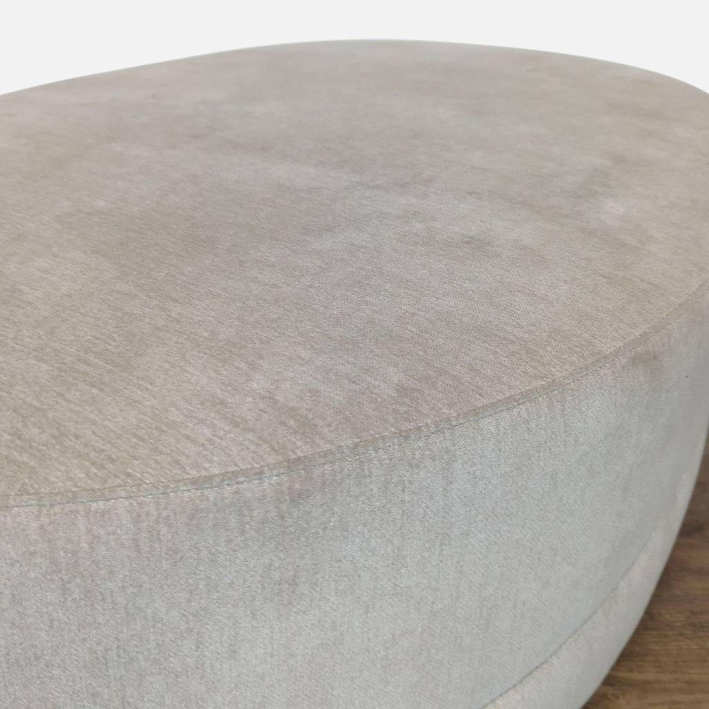 2. Close-up of the smooth fabric texture and stitching on a Reperch oval ottoman.