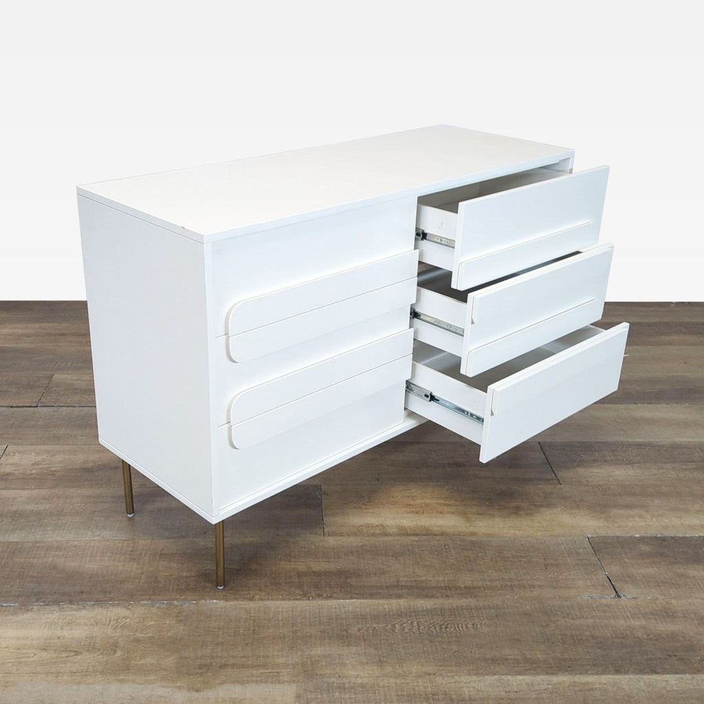 2. Side view of a Williams Sonoma dresser with 6 drawers, some open, and slim metal legs.