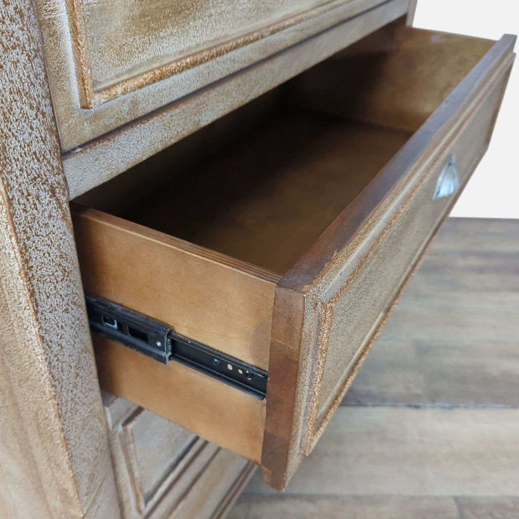3. Closeup of a Pottery Barn dresser drawer on metal glide, featuring panel design and silver cup pull.