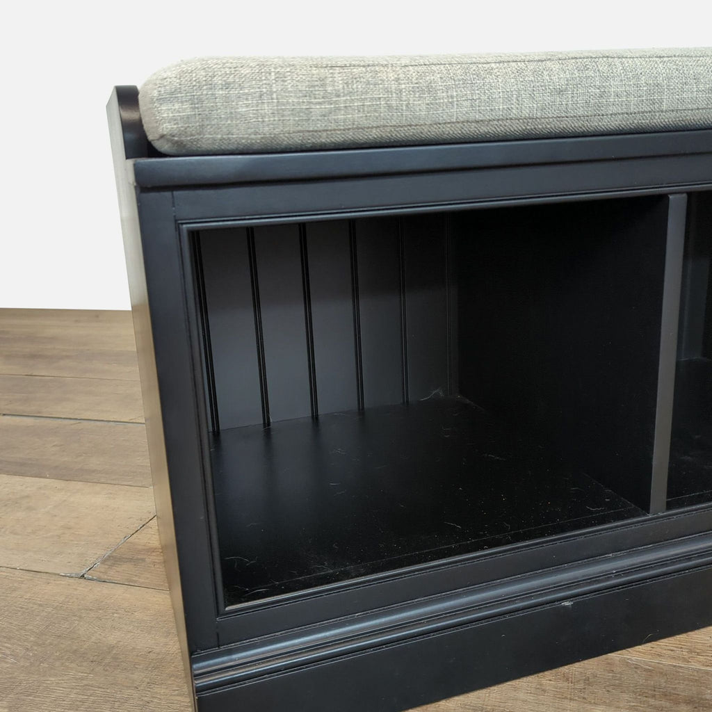 3. Detail view of Pottery Barn bench's black cubby compartment with paneled backing and trim.