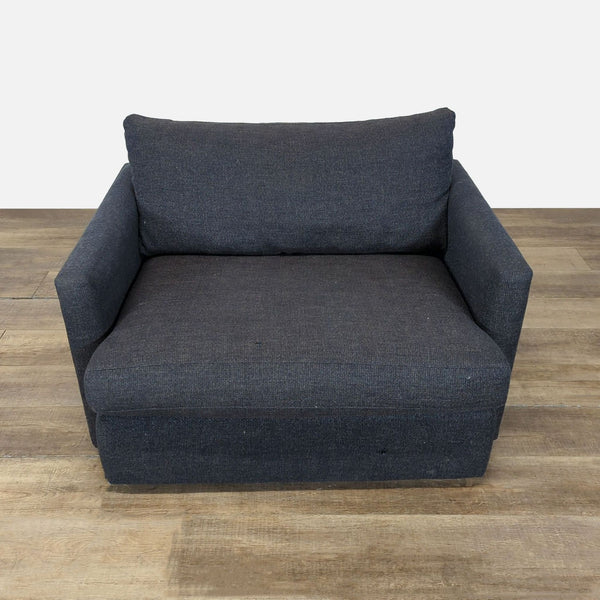 Front view of a dark fabric lounge chair by Crate & Barrel, featuring a deep low seat and slim track arms.