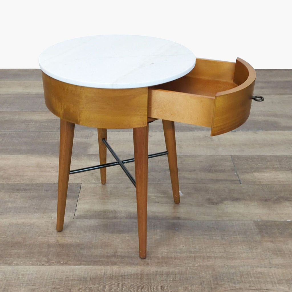 2. West Elm wood end table features a round marble top and an open curved drawer, showing interior storage space.