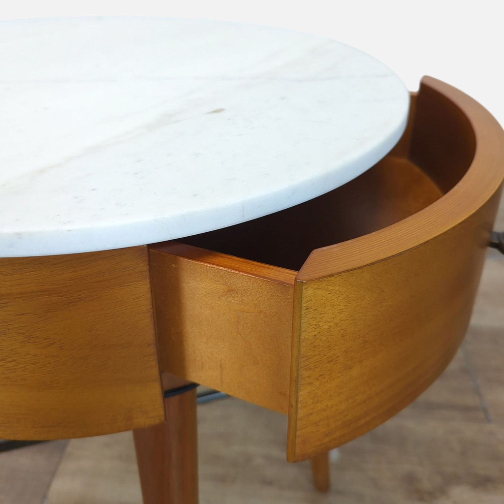 3. Close-up of West Elm end table’s white marble top and open wood drawer, highlighting curved design and finish.