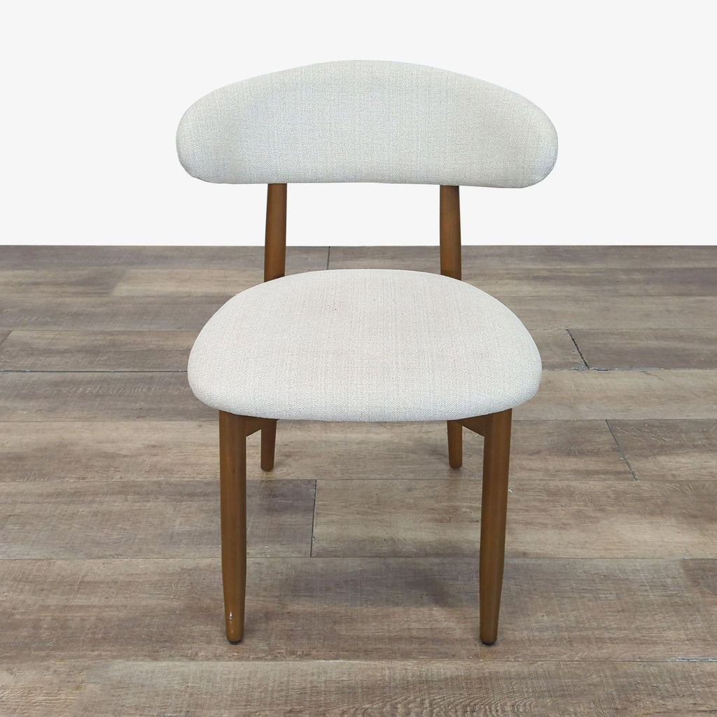 1. Front view of a West Elm dining chair with a light fabric seat and back on a wooden frame.  