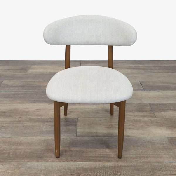 1. Front view of a West Elm dining chair with a light fabric seat and back on a wooden frame.  