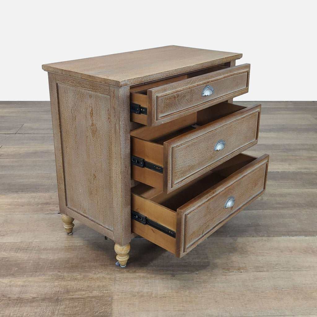2. Three-drawer Pottery Barn dresser showing all drawers open, molded trim and lathe turned legs, wood finish.