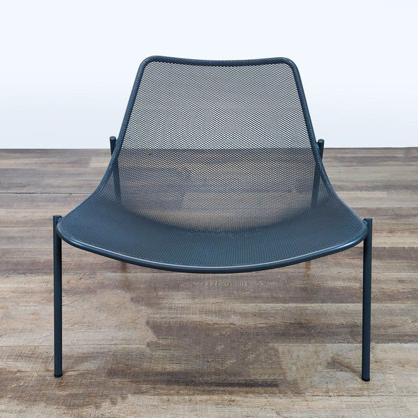- Front view of a Reperch chair with a curved metal mesh seat and backrest, set in a steel tube frame.