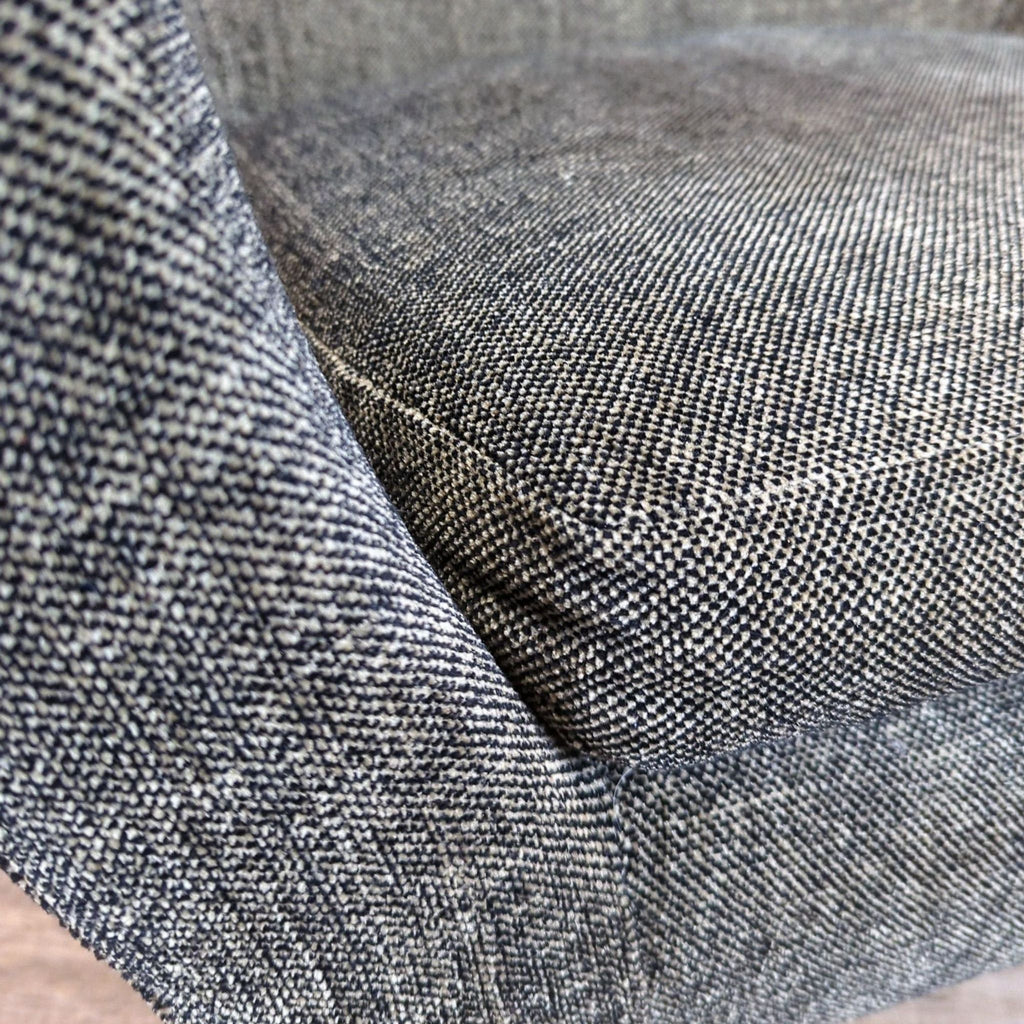Close-up of the textured gray tweed fabric upholstery on the Reperch lounge chair seat.