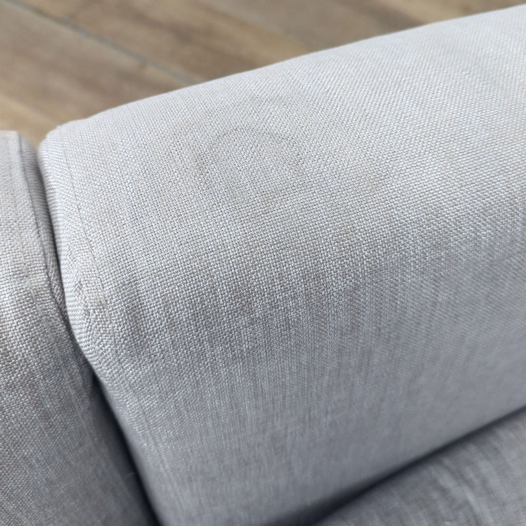 3. Close-up of the light gray fabric upholstery on a Bo Concept loveseat sleeper sofa.