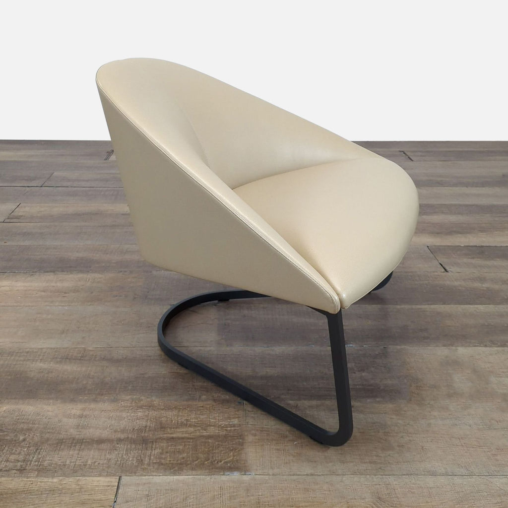 2. Side view of an Arper lounge chair showing curved support in beige upholstery and minimalist black metal frame.