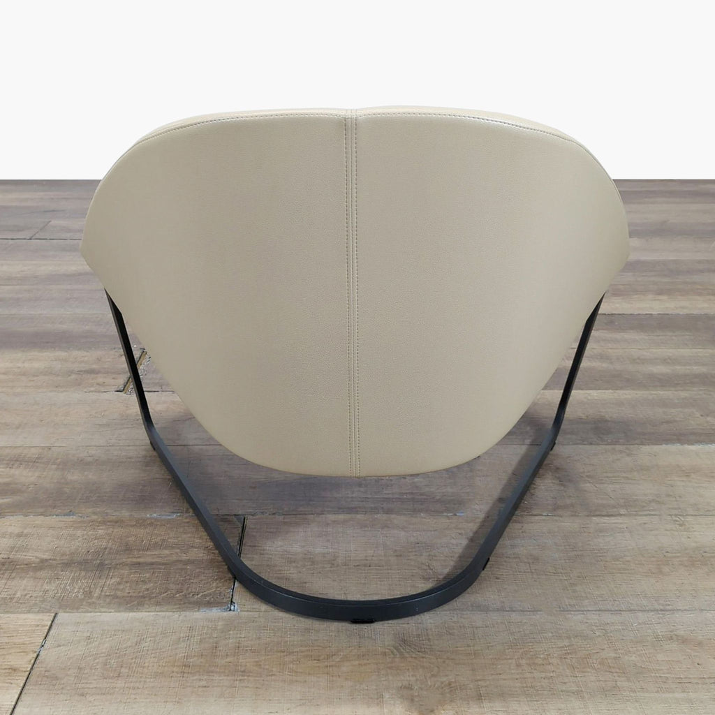 3. Rear view of an Arper lounge chair, highlighting the curved backrest and black metal sled base design.