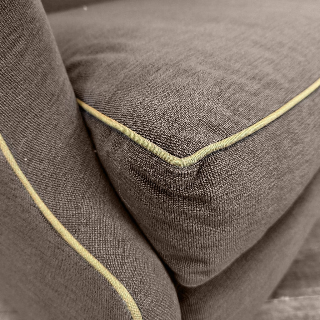 3. Closeup of loveseat upholstery, highlighting tan piping and tailored stitching details on armrest and cushion.
