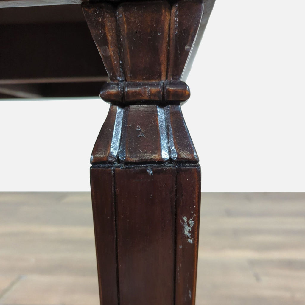 2. Close-up of a carved leg from a South Cone end table, showing dark wood with detailed grooves and minor wear.