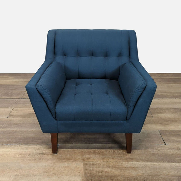 1. Front view of a Reperch lounge chair with blue tufted seat and back, and angular wooden legs.