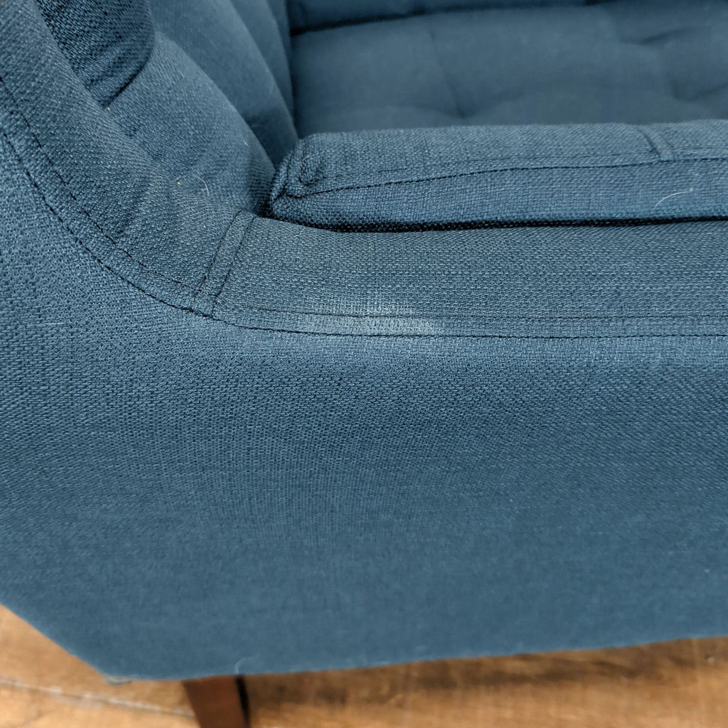 3. Close-up of blue fabric and tufting detail on a Reperch lounge chair, highlighting minor wear.