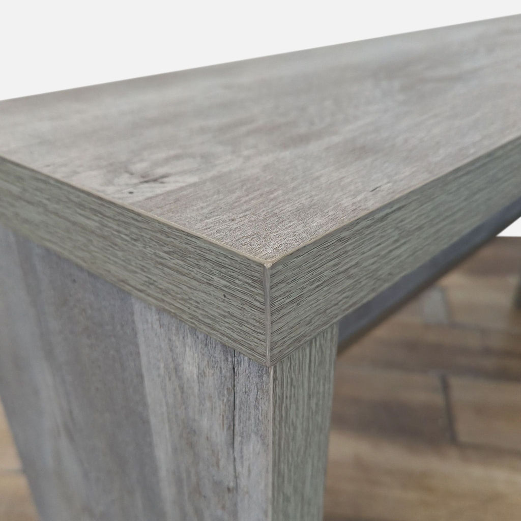 2. Close-up of the Reperch console table’s corner detailing, highlighting the textured gray wood surface.