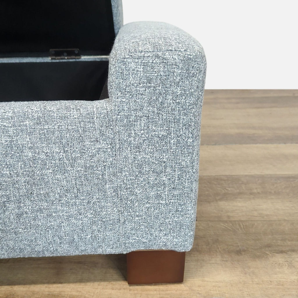 3. Close-up of the textured grey fabric and wooden leg of the Reperch ottoman bench from Stools, Ottomans & Benches.
