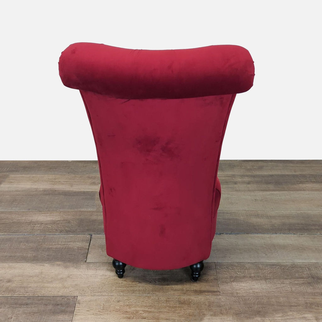 3. Back view of Reperch red velvet tufted lounge chair with curved top and turned wood legs.