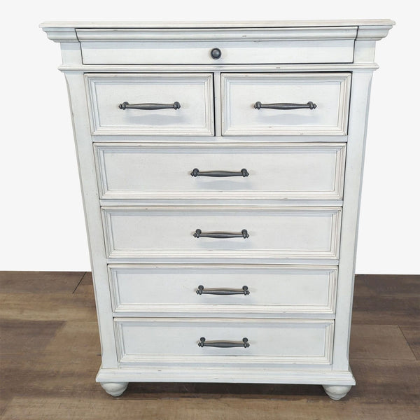 1. White Ashley Furniture dresser with generously scaled molding, bun feet, and transitional-style handles on wood floor.