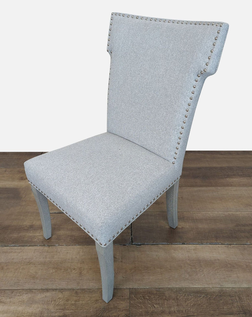 2. Angled side view of a Reperch dining chair, showing textured grey fabric and light wood legs.