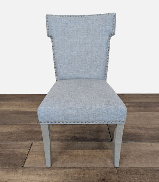 1. Front view of a Reperch dining chair with light blue upholstery and nailhead trim on a wood floor.