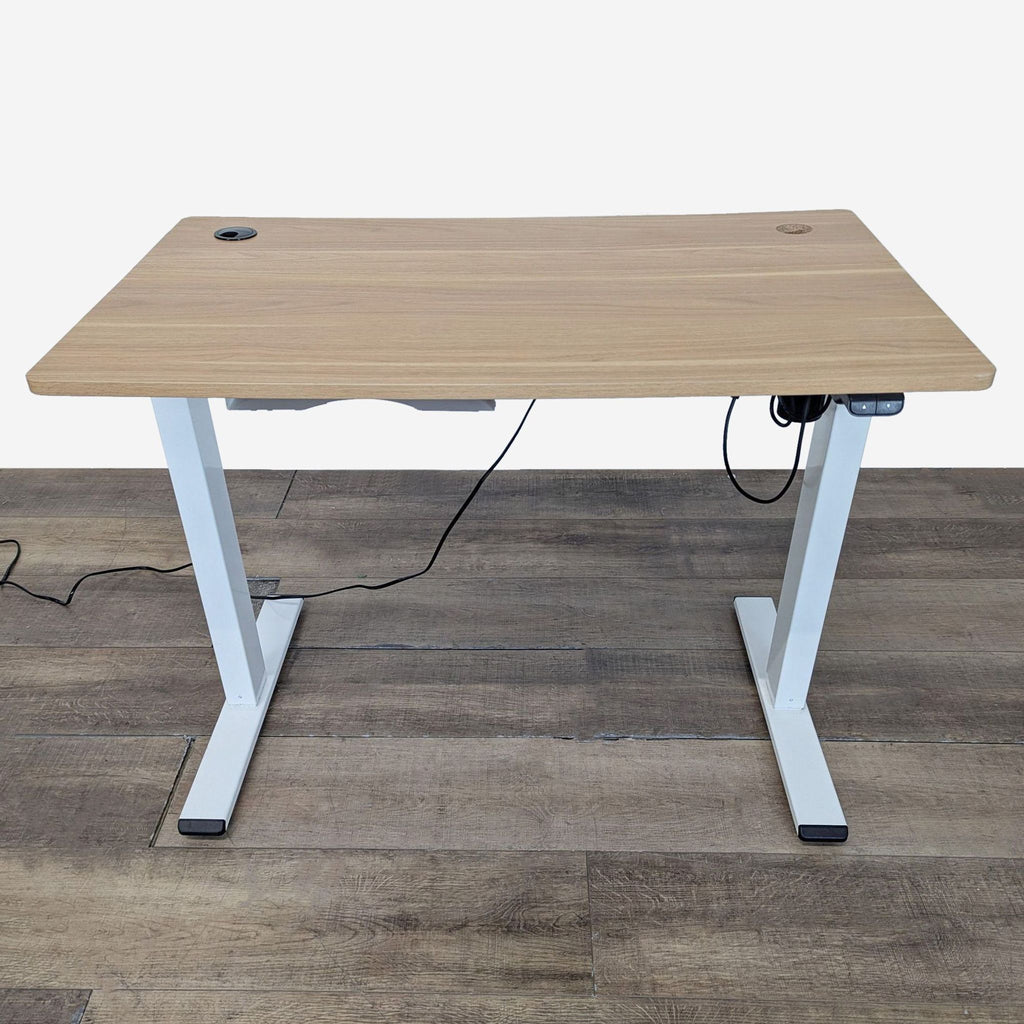1. Electric height adjustable Reperch desk with a light wood top, white legs, and cable management holes.  