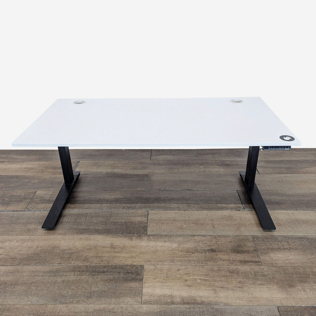 1. Jarvis desk with a white top, black legs, and built-in cord management on a wooden floor.