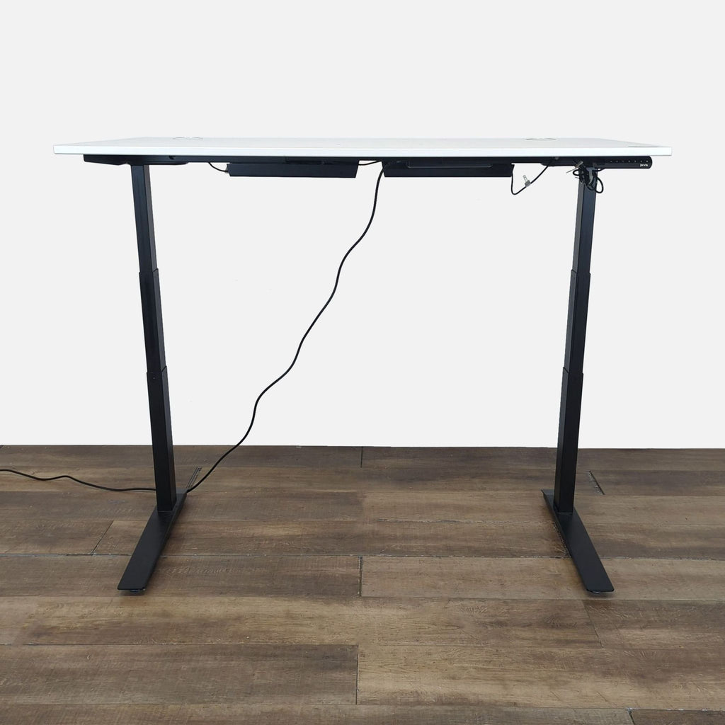 3. Side view of a Jarvis standing desk showing black legs, cord management, and adjustable height feature.