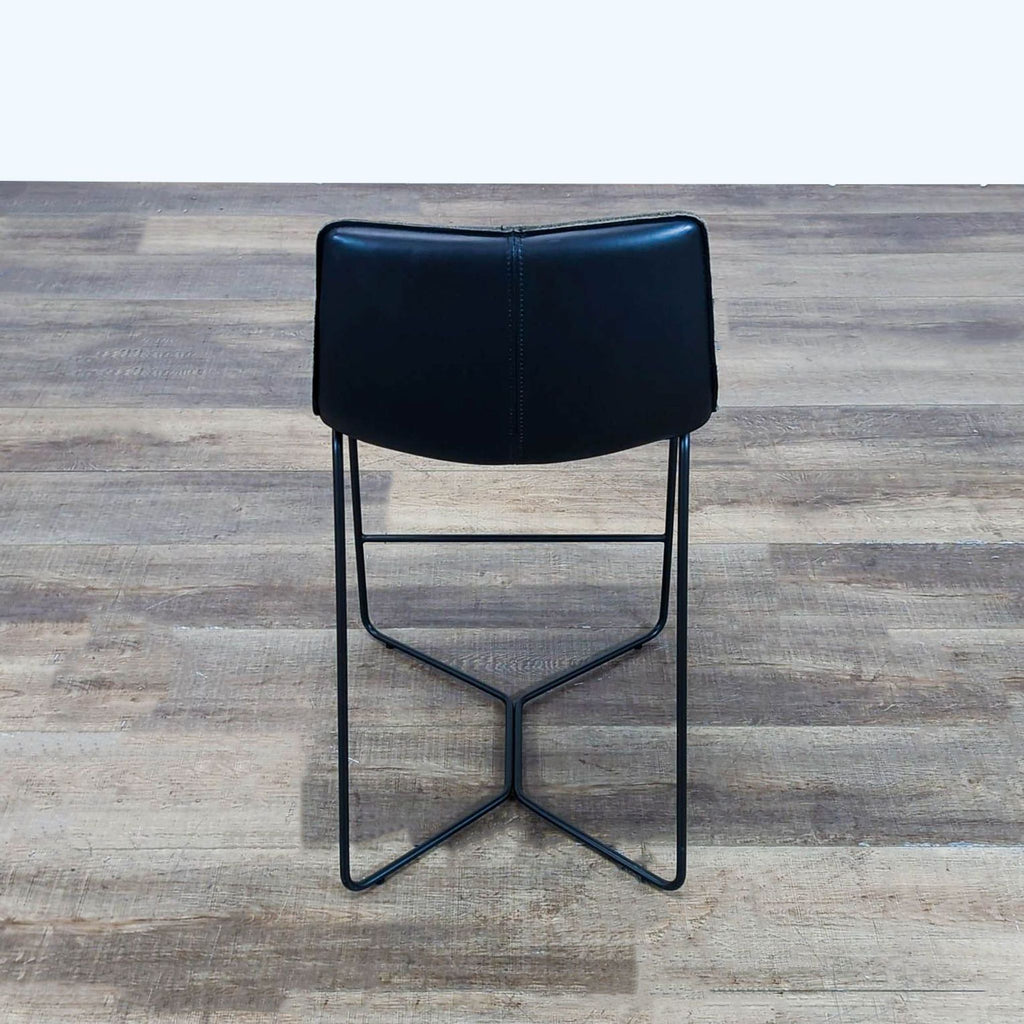 3. Rear view of a sleek black West Elm stool featuring a curved backrest and slender metal frame.