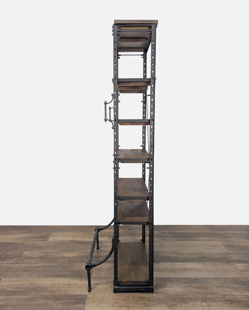 2. Side view of Restoration Hardware bookshelf featuring five wooden shelves, upper handles, and a lower metal foot rest.  